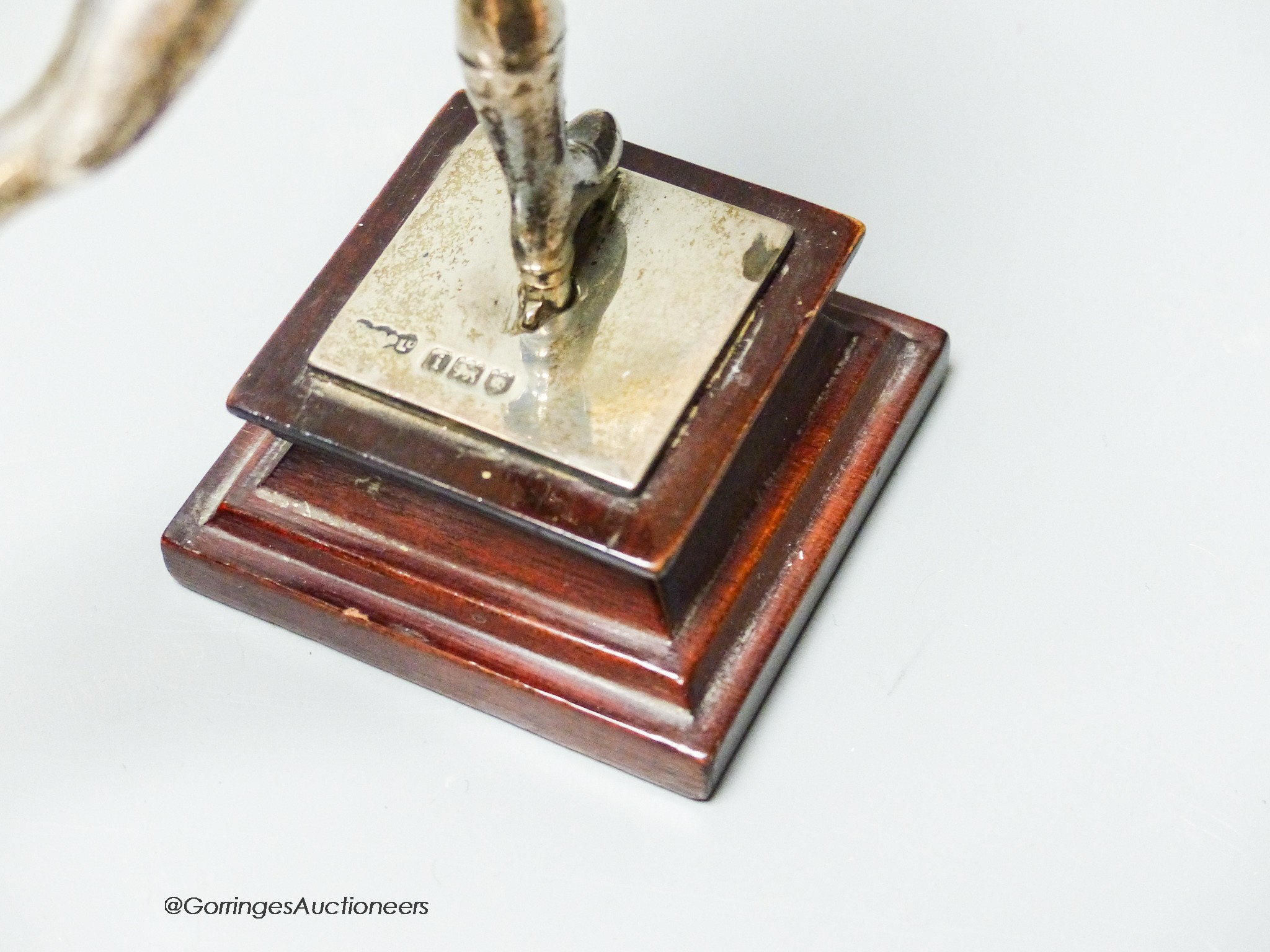 An Edwardian silver miniature model of an ice skater, Elkington & Co Ltd?, London, 1904, on a wooden plinth base, skater 12cm, gross weight 10oz.